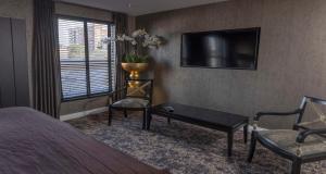 a bedroom with a bed and a tv and a chair at The Bold Hotel; BW Signature Collection in Southport