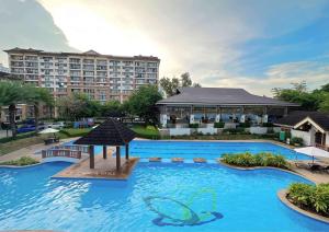 a large swimming pool with a large building in the background at One Oasis 2BR Condo in Mabolo-near SM, Ayala, IT park in Cebu City