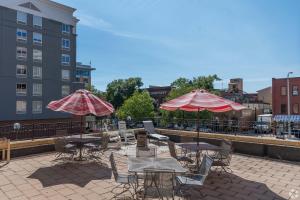 a patio with tables and chairs and umbrellas at City Hall Clerk's Office in Rochester