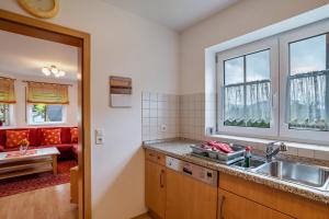 a kitchen with a sink and a living room at Ferienhof Mayer in Lautenbach +69 photos