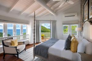 Un dormitorio con una cama y una silla y ventanas. en Windjammer Landing Resort and Residences, en Gros Islet