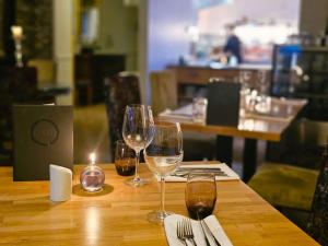 a table with wine glasses and a candle on it at Burlington Berties in Sheringham