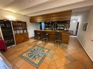 a kitchen with a bar with chairs and a rug at Hotel Castillo Valdés Salas in Salas