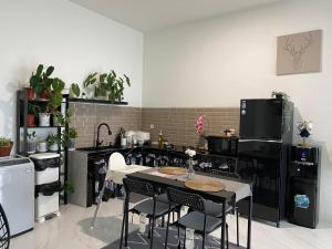 a kitchen with black appliances and a table and chairs at Casa Revanaka Ciumbuleuit Bandung in Bandung