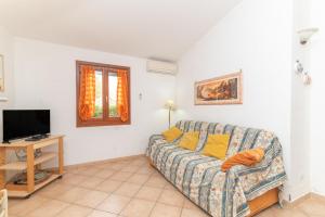 a living room with a couch and a tv at Villa San Teodoro in Nuragheddu