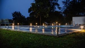 a swimming pool with lights in a park at night at Swag Vista Resort in Anachal