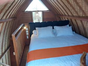 a bed in a wooden room with a window at Thula Thula Bali Villas in Kerobokan