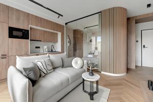un soggiorno con un divano bianco e una cucina di Flatbook - City Center SPA Apartments Grano Residence with Parking a Danzica