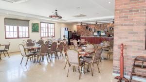 a restaurant with tables and chairs and a brick wall at Hotel Galeria in Santiago