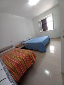 1 dormitorio con cama y manta colorida en Villa degli Ulivi, en Montecorvino Rovella