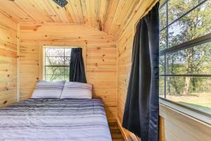 una cama en una cabaña de troncos con ventana en Riverfront Cabin Near Yellowstone Lake State Park, en Blanchardville