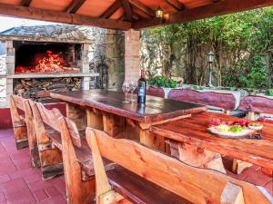 a wooden table and chairs on a patio with a fireplace at Holiday Home Nika by Interhome in Kršan