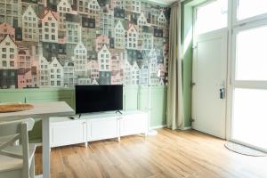 a living room with a tv and a wall of buildings at Moderno Bilocale con Aria Condizionata vicino a Duomo, Fondazione Prada e IEO in Milan