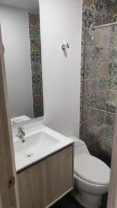 a bathroom with a white toilet and a sink at Vivienda Turística Ángel 1 in Salento