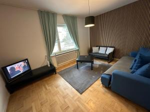 a living room with a blue couch and a tv at Apartment Telefonplan Stockholm in Stockholm