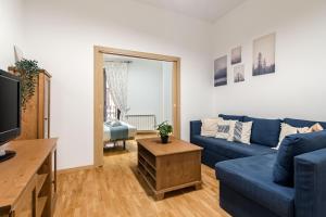 a living room with a blue couch and a tv at Plaza Mayor II - Apartamento de 2 dormitorios in Madrid
