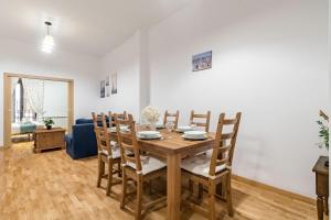 a dining room with a wooden table and chairs at Plaza Mayor II - Apartamento de 2 dormitorios in Madrid +12 photos