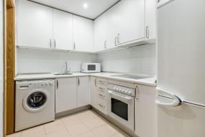 a kitchen with white cabinets and a washer and dryer at Plaza Mayor II - Apartamento de 2 dormitorios in Madrid