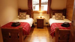 a bedroom with two beds and a window in it at Chalet Mimi in Morzine