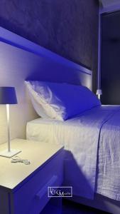 a bedroom with a bed with a nightstand with a pillow at La Chic Maison in Corbara