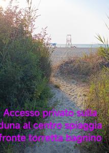 a sandy beach with a structure in the background at VILLALoddo4 Marina di Tertenia cap 08047 dietro Ristorante La Grotta in Tertenìa