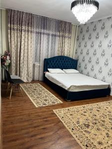 a bedroom with a bed and a chandelier at Bishkek Residence Apartment in Bishkek