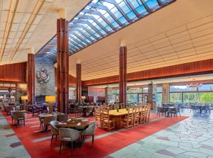 a lobby with tables and chairs and a restaurant at Fairmont Jasper Park Lodge in Jasper