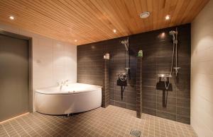 a bathroom with a bath tub and a sink at Rukavuorenhuippu Apartment in Ruka +39 photos