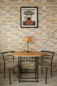 a table with two chairs and a table with a lamp at Anna Apartman in Százhalombatta +2 photos