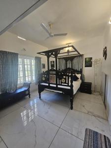 a bedroom with a large bed and a couch at PADIKKAL BUNGLOW in Vayittiri