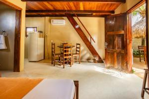 a kitchen with a refrigerator and a table and chairs at Pousada Chale Creoulo in Jericoacoara