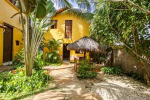 a yellow house with a table and chairs in front of it at Pousada Chale Creoulo in Jericoacoara