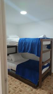 a bunk bed with blue sheets on top of it at Vivienda Turística Ángel R2 in Salento