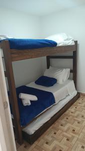 a bunk bed with blue sheets and white pillows at Vivienda Turística Ángel R2 in Salento