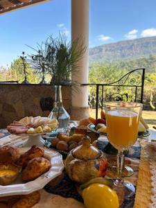 a table with food and a glass of orange juice at Segredo da Serra Guest House in Tiradentes
