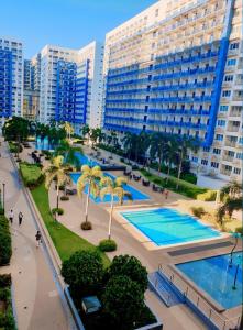 - une vue sur un complexe avec une piscine et des bâtiments dans l'établissement Sea Residences Moa Pasay City - Dar Condotel, à Manille
