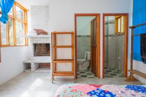 a room with a bathroom with a toilet and a mirror at Backpackers-balcones-river-lodge in Baños +231 photos