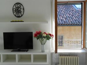 a living room with a tv and a vase with flowers at Il Teatro in Bergamo