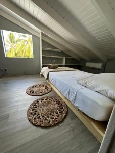 a bedroom with two beds and two rugs on the floor at Villa NO&LO in Sainte-Anne