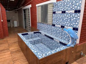 una bañera de azulejos azules con un delfín azul. en Chalé Jane, en Caldas Novas