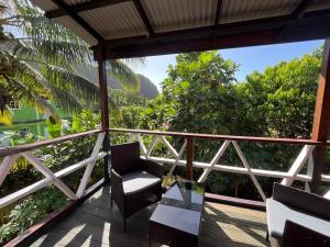a balcony with chairs and a view of the mountains at Anthurium Apartment in Roseau