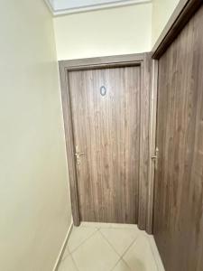 a wooden door in a room with a tile floor at charming room close to Marrakech airport in Marrakech +4 photos