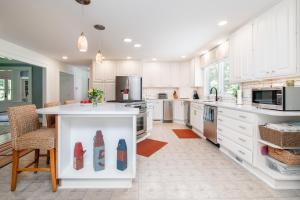 a kitchen with white cabinets and a kitchen island with red shoes at Baydream Believer in Saint Michaels