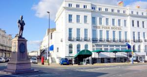 a statue in front of a white building at The Pier Hotel in Eastbourne