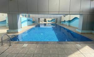 a large swimming pool with blue water in a building at Skyline View Premium Apartment in Dubai