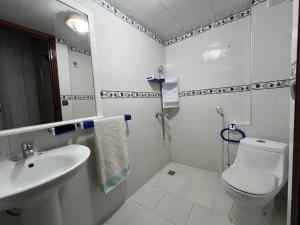 a white bathroom with a toilet and a sink at شقة مفروشة تطل على طبيعة جميييلة in Ouazzane