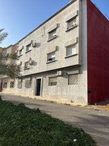 a concrete building with a red wall and a street at شقة مفروشة تطل على طبيعة جميييلة in Ouazzane +3 photos