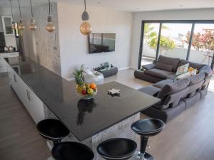 a kitchen and living room with a large island with a table at A Casa do Góis - Villa in Porto Santo in Porto Santo