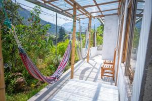 a porch with hammocks on a house with a view at Backpackers-balcones-river-lodge in Baños