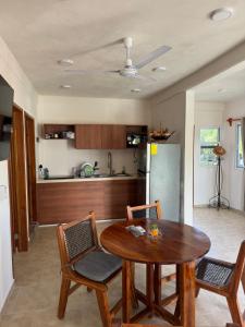 a kitchen with a table and chairs and a refrigerator at Apartamento cerca del mar in Puerto Morelos